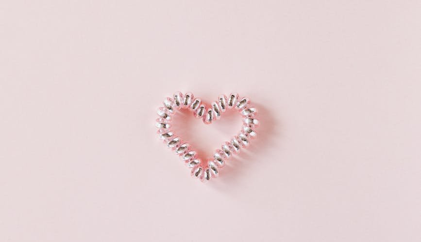 decorative heart of elastic coil on pink background