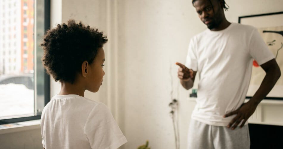young black father edifying calm son at home