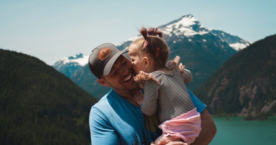 a little girl giving her dad a kiss
