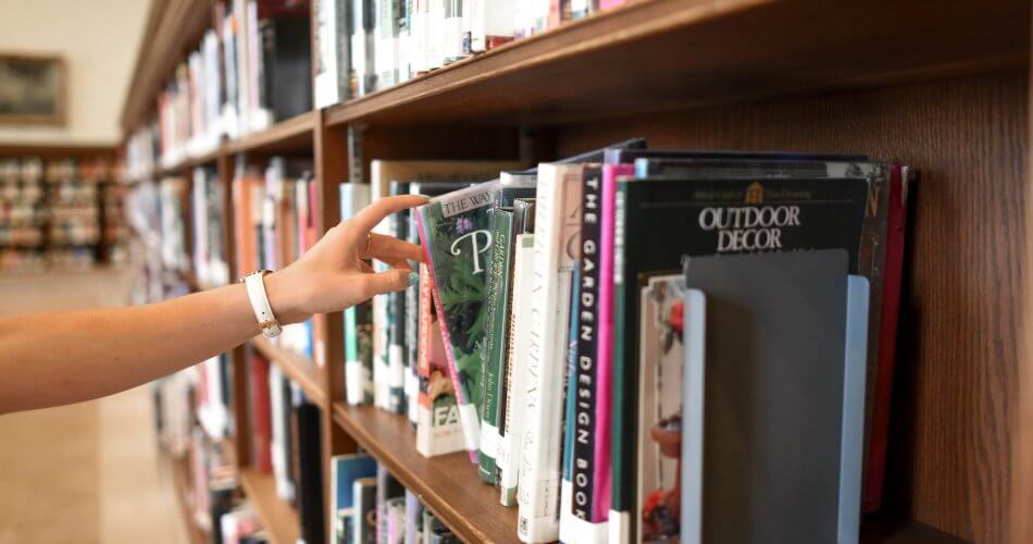 person holding book from shelf